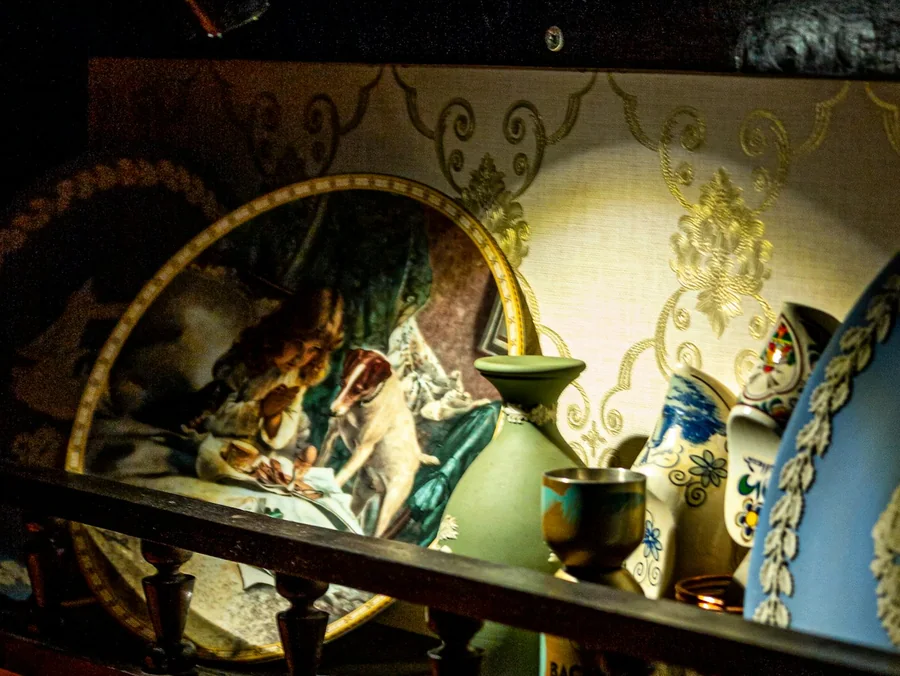 Antik porcelán tálak, vázák és dísztárgyak vitrinben